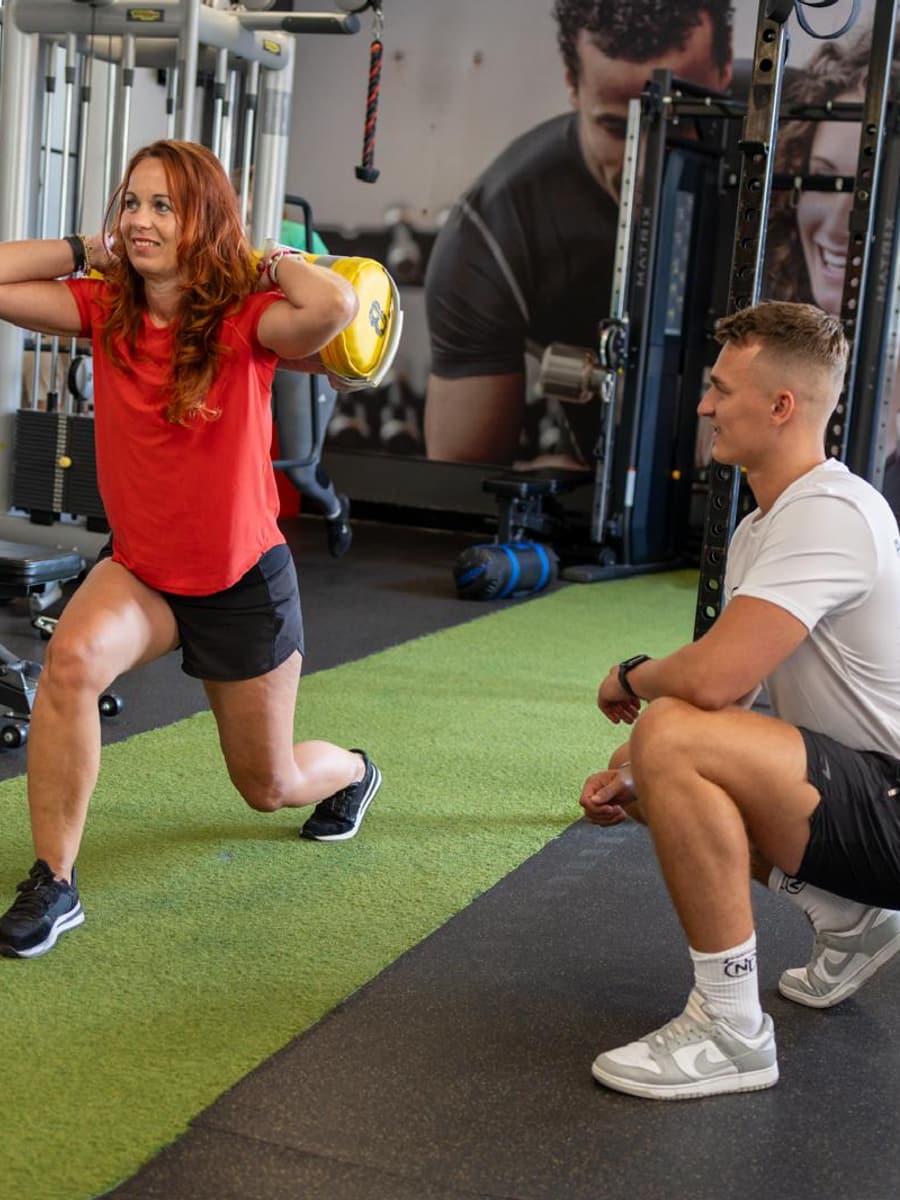 Niek coacht een klant tijdens een lunge met sandbag