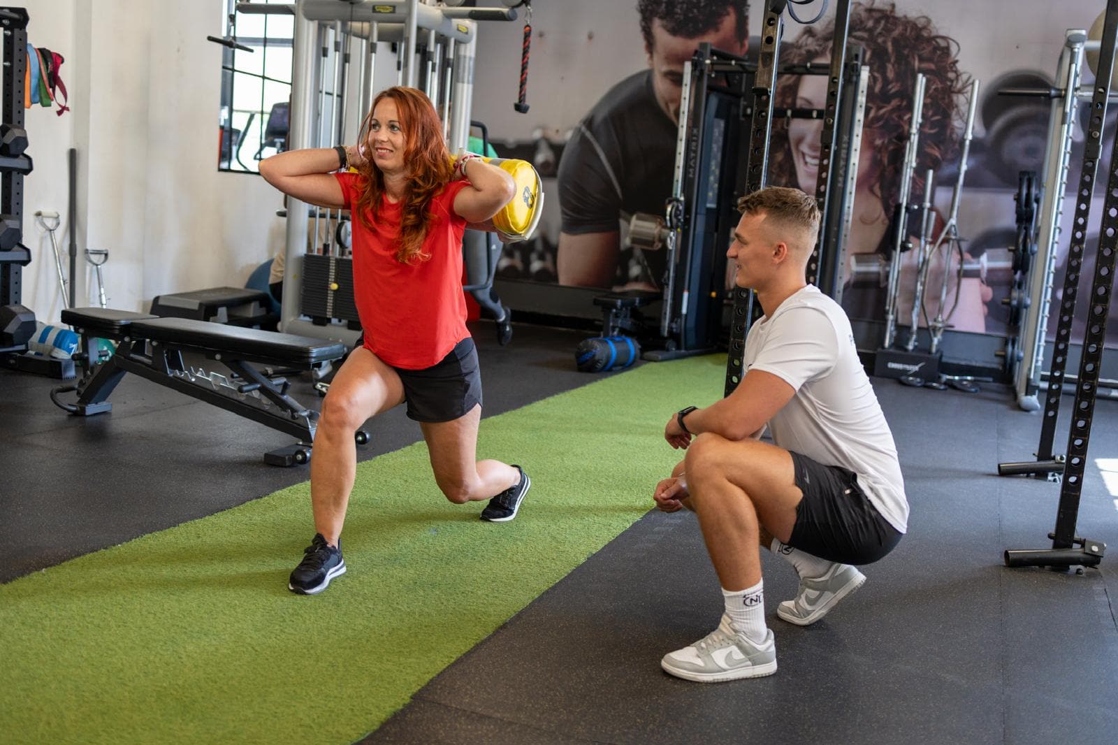 Niek coacht een klant tijdens een lunge met sandbag